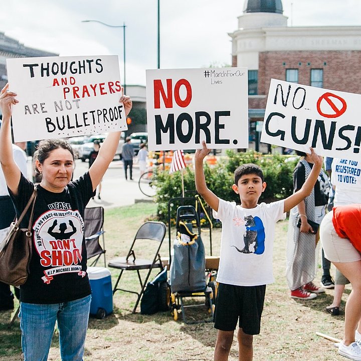 Protestors hold signs against guns ©Heather Mount / unsplash.com