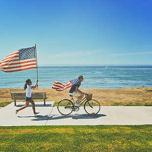 Junge Leute mit amerikanischer Flagge am Strand ©frank mckenna / unsplash.com