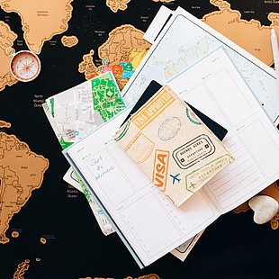 Reiseunterlagen auf einer Weltkarte ©Nataliya Vaitkevich / pexels.com
