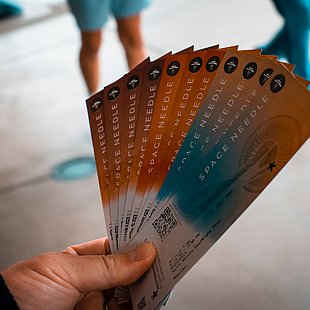 Eine Hand hält mehrere Eintrittskarten ©Andy Li / unsplash.com