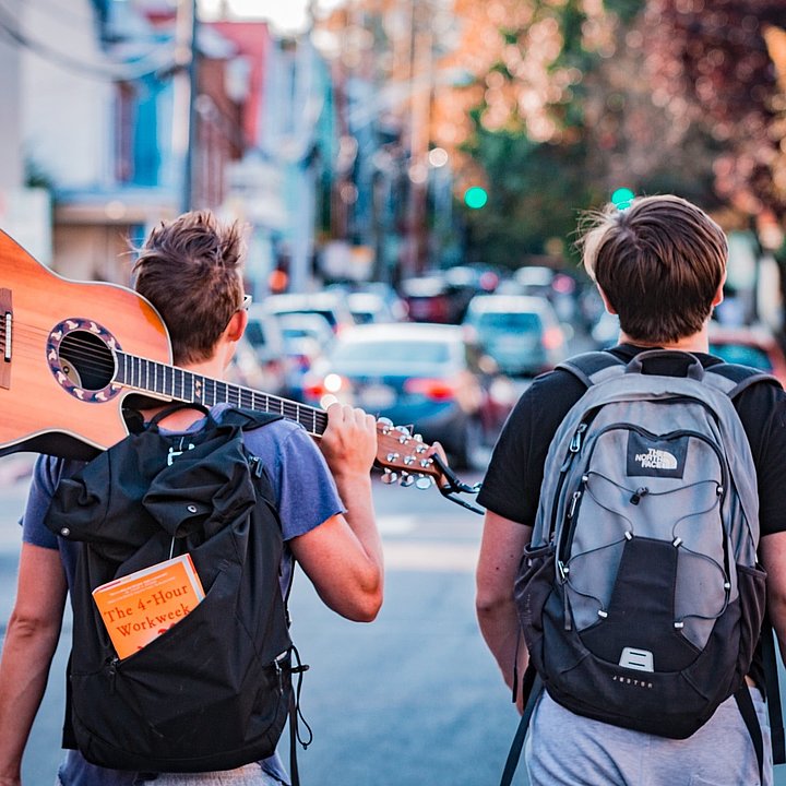 Zwei junge Männer mit Rucksack und Gitarre © Austin Distel / unsplash.com