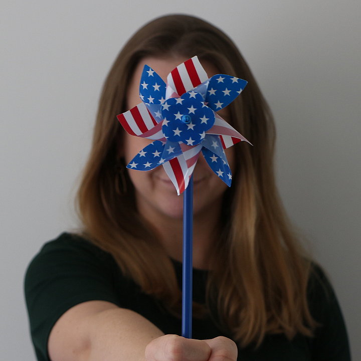 Junge Frau hält Windrädchen in den amerikanischen Farben ©Amerikahaus