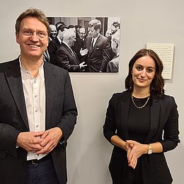 Andreas Etges und Alexandra Schenke vor einem Ausstellungsbild quer (c) Amerikahaus München