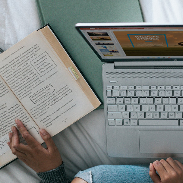 Person sitzt auf einem Bett mit Laptop und Bücher ©Windows / unsplash.com